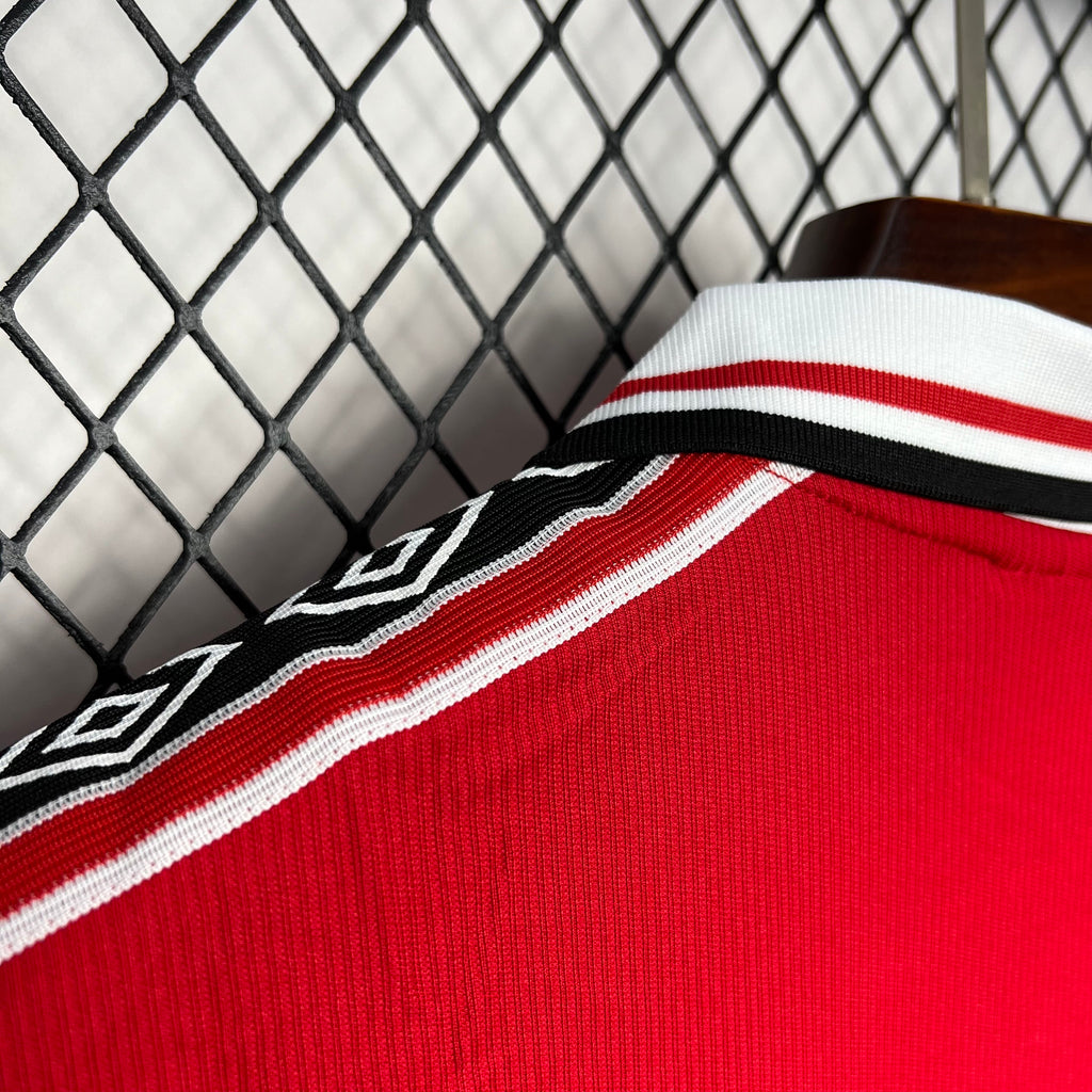 Red knit soccer jersey fabric with white-and-red shoulder stripe and black piping detail