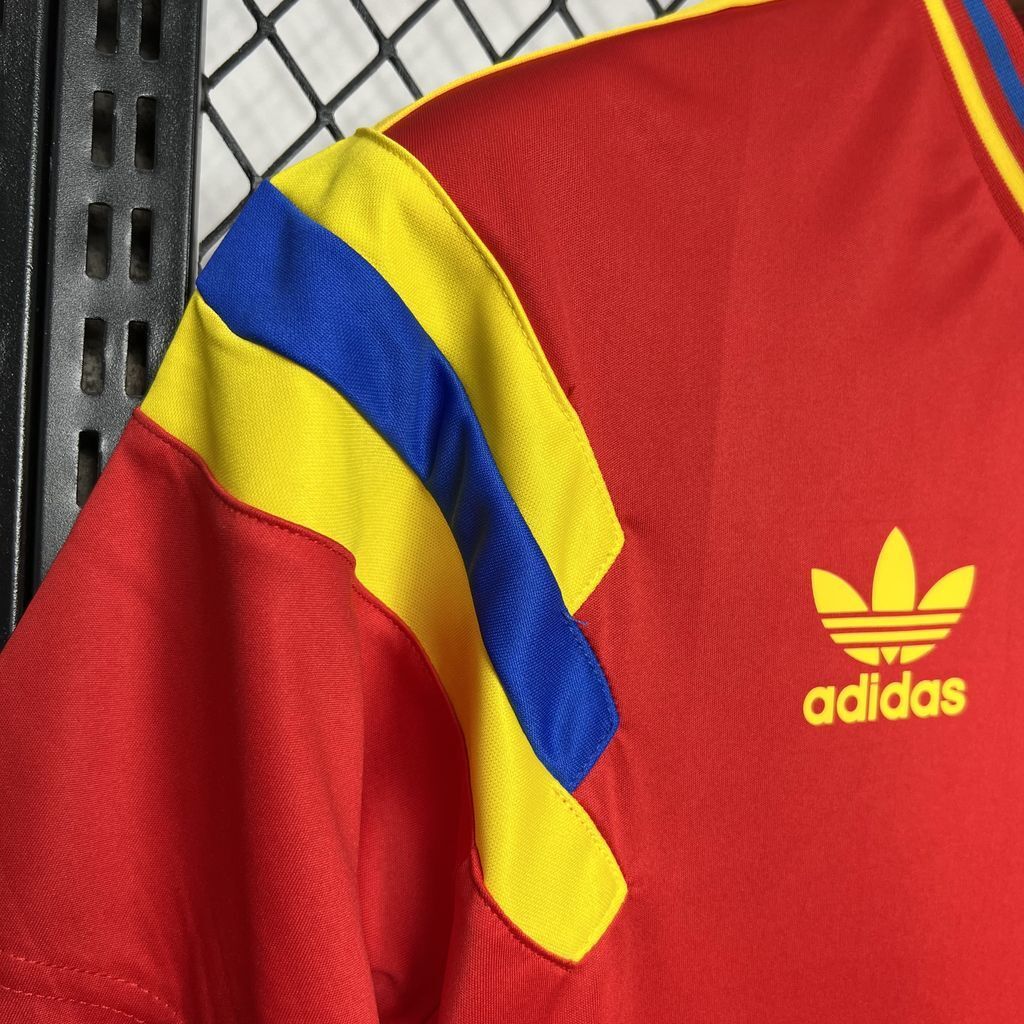 Red jersey sleeve with yellow and blue stripes plus Adidas trefoil logo