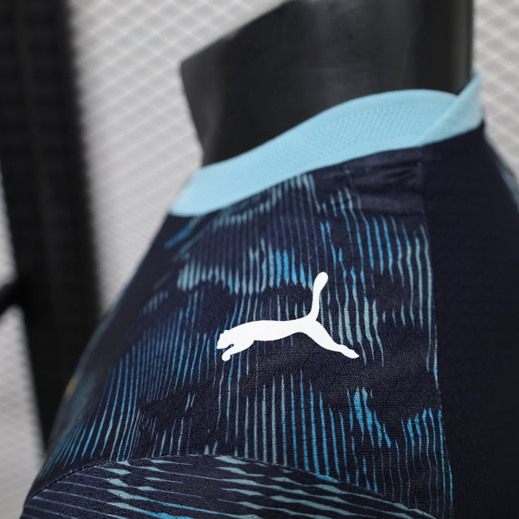 Close-up of white Puma logo on navy-and-blue patterned jersey sleeve