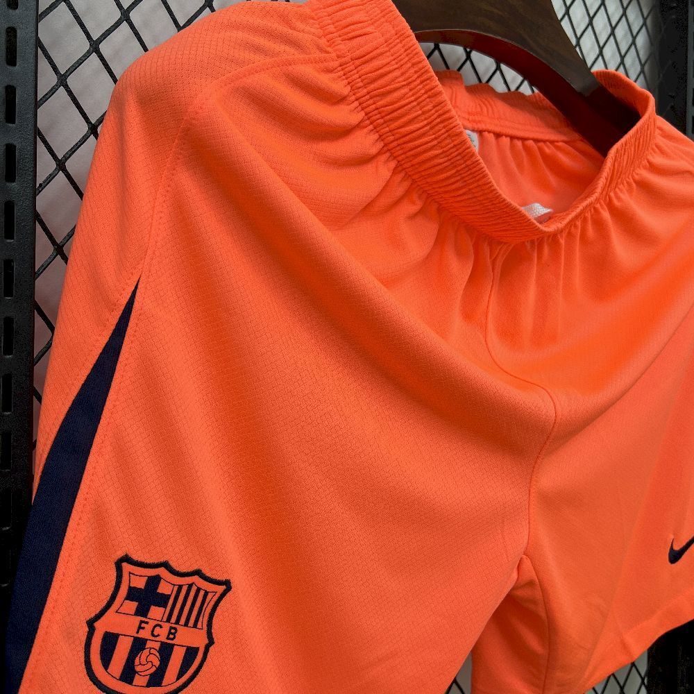 Orange football shorts with elastic waistband and FC Barcelona crest, side swoosh