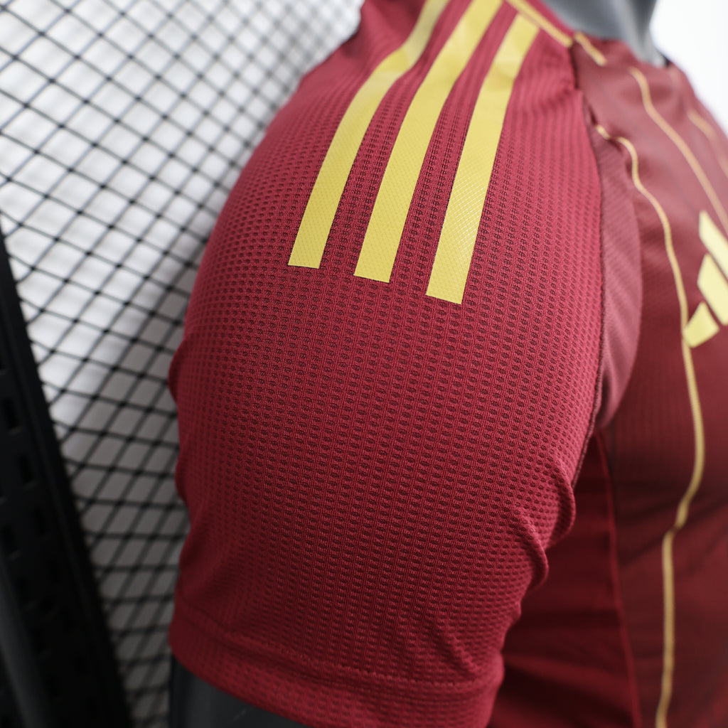 Maroon jersey sleeve with three gold adidas stripes detail