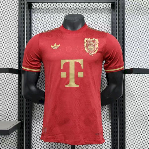 Red player jersey with gold FC Bayern 125th crest, Adidas trefoil, and large TG monogram