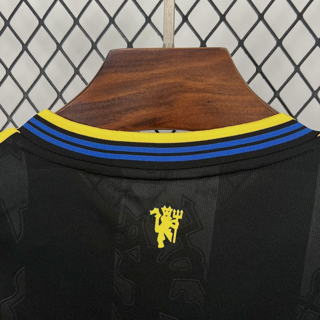 Women's third jersey collar close-up, yellow-and-blue V trim on dark fabric.