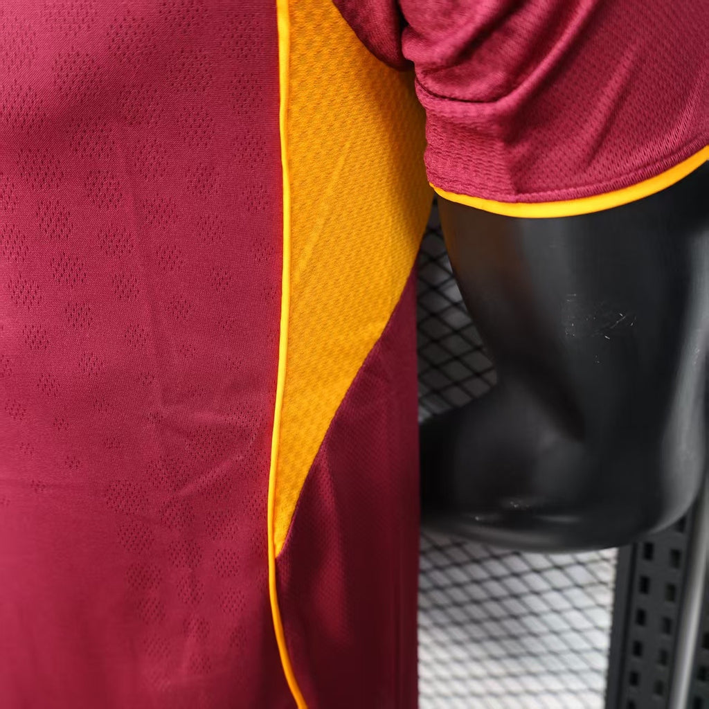 Maroon jersey side seam detail with yellow piping along the arm opening.