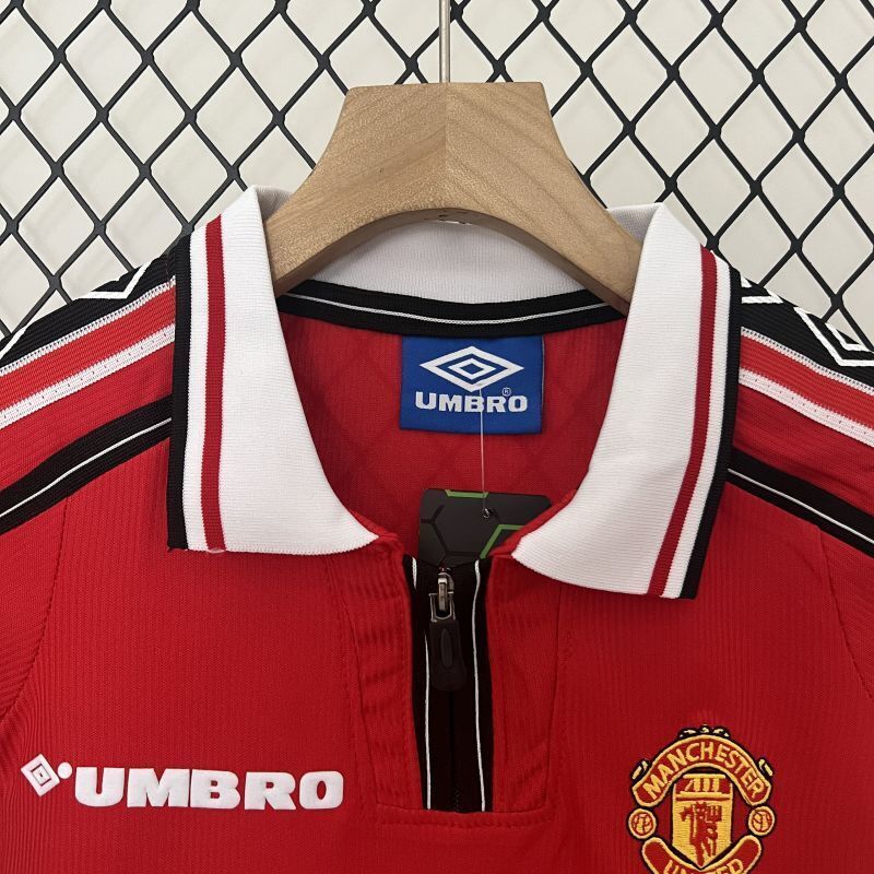 Red kids soccer jersey with white-trim collar, Umbro logo, and Manchester crest