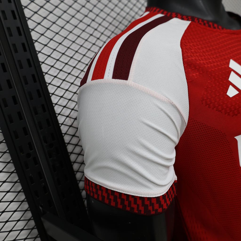 Arsenal home football jersey sleeve detail, white cuff with red trim and shoulder stripes