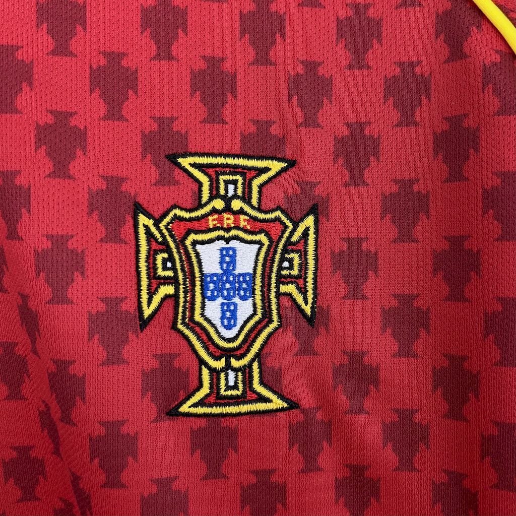 Portugal crest badge on red retro football jersey, gold and blue emblem