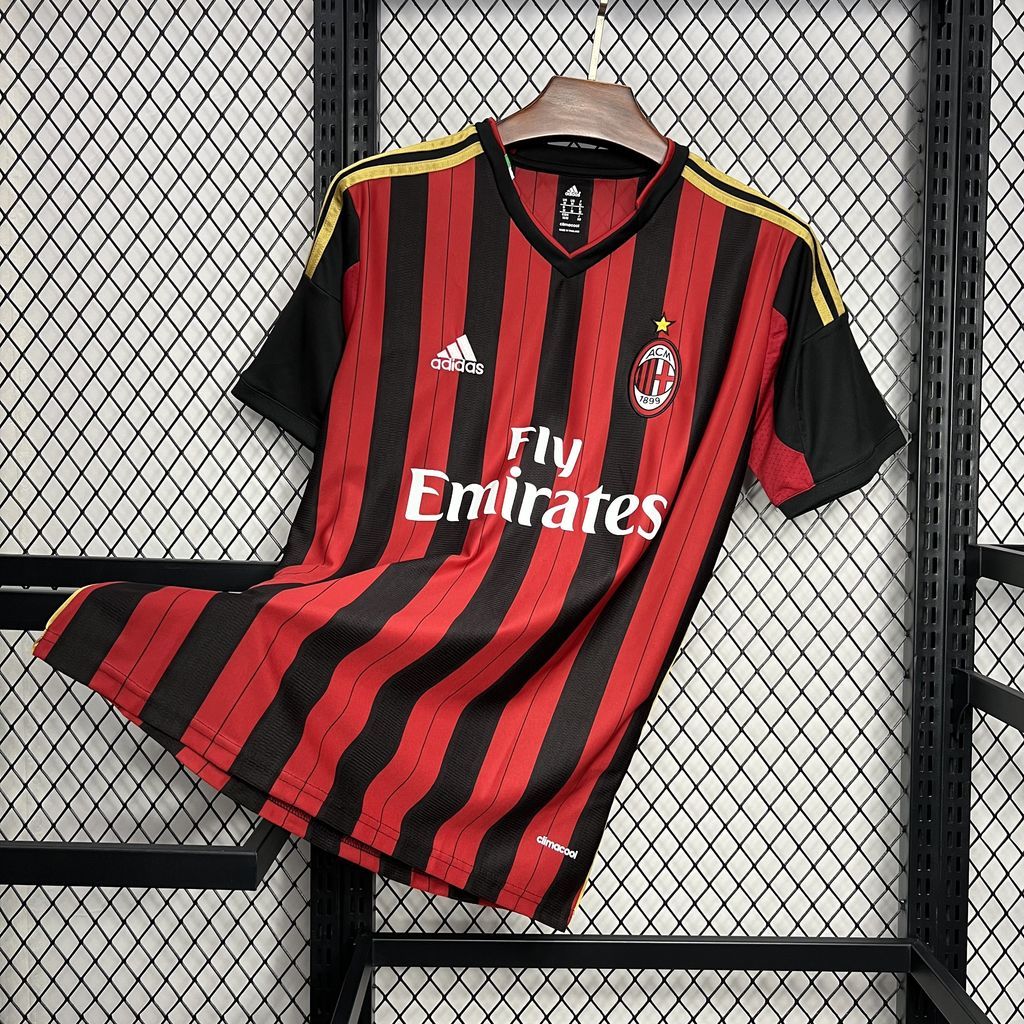 AC Milan home soccer jersey folded on display, red-and-black vertical stripes and Fly Emirates