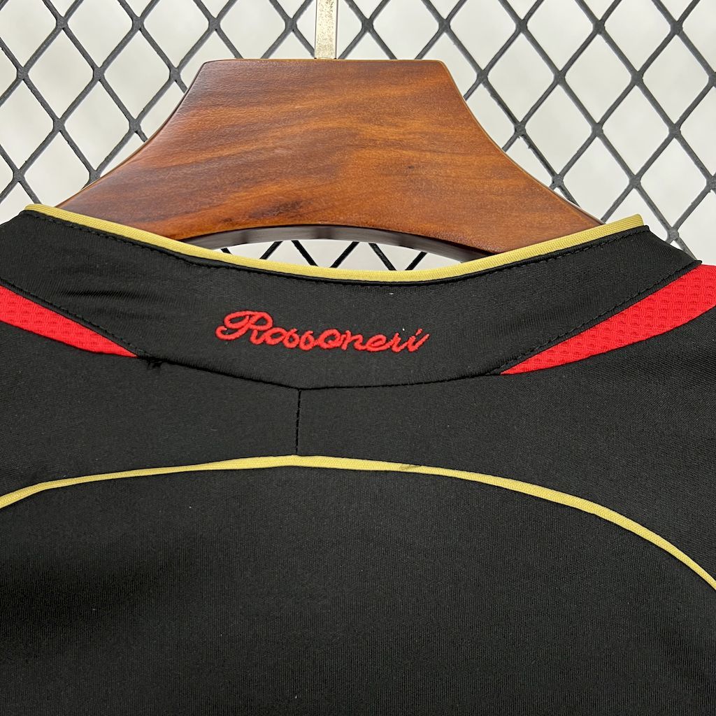 Black jersey neckline detail with yellow-and-red piping and embroidered script logo