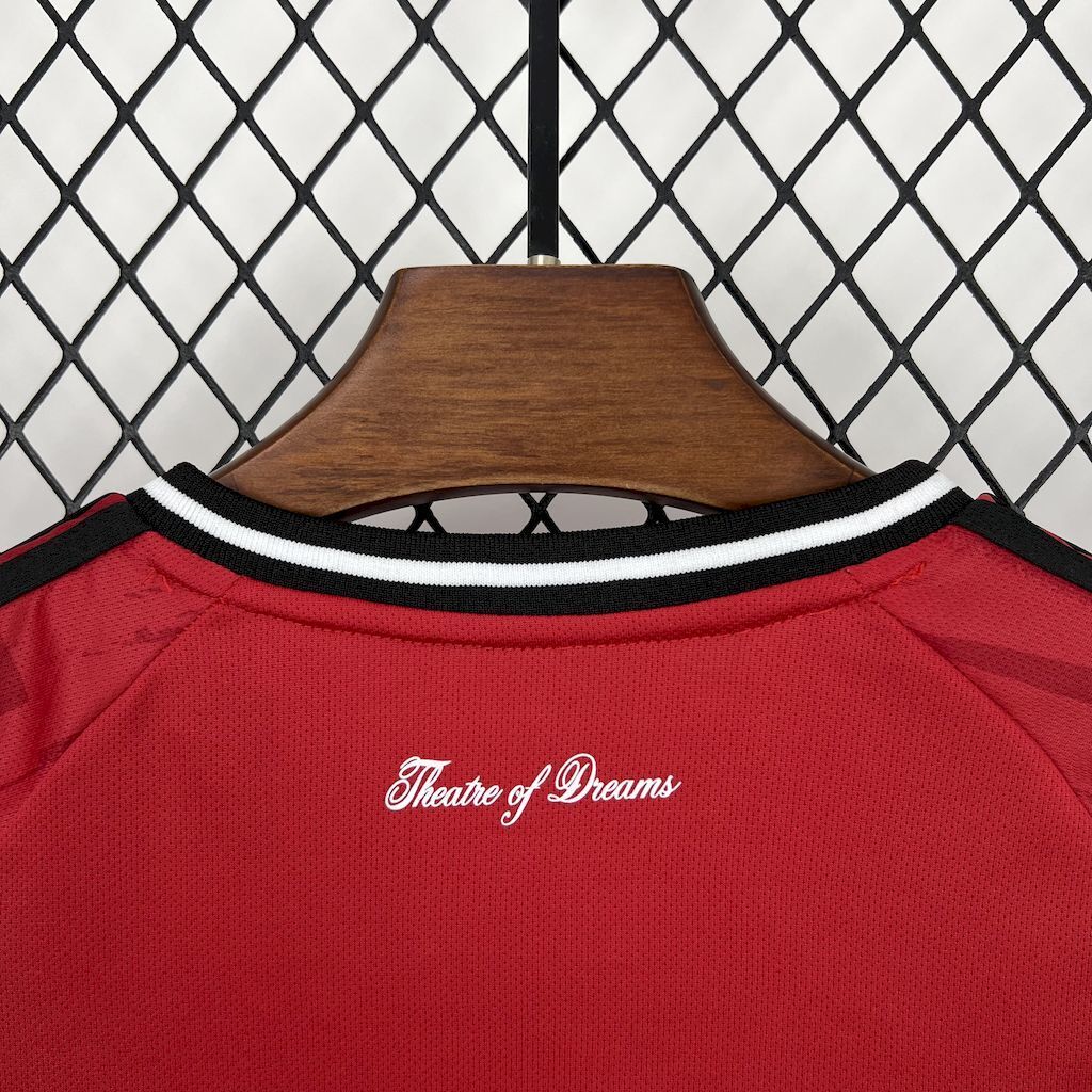 Kids red home football shirt neckline with black-and-white striped collar and center text