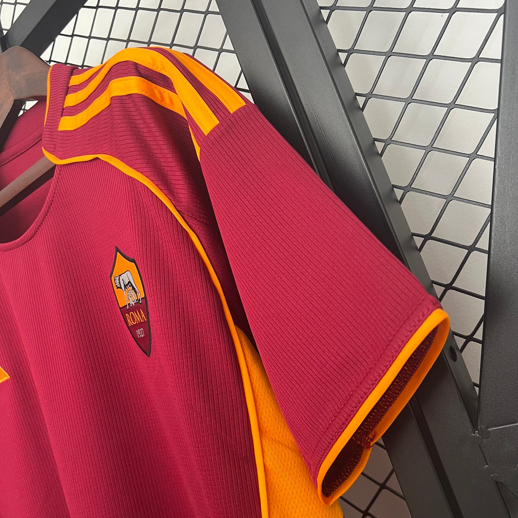 Maroon soccer jersey sleeve with Roma crest and yellow inner collar trim