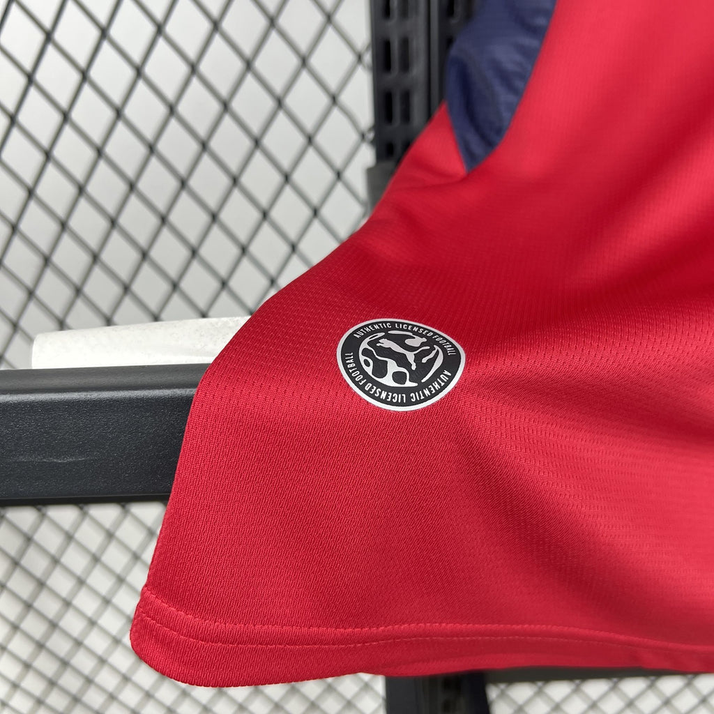 Red jersey sleeve with round sponsor logo patch near hem