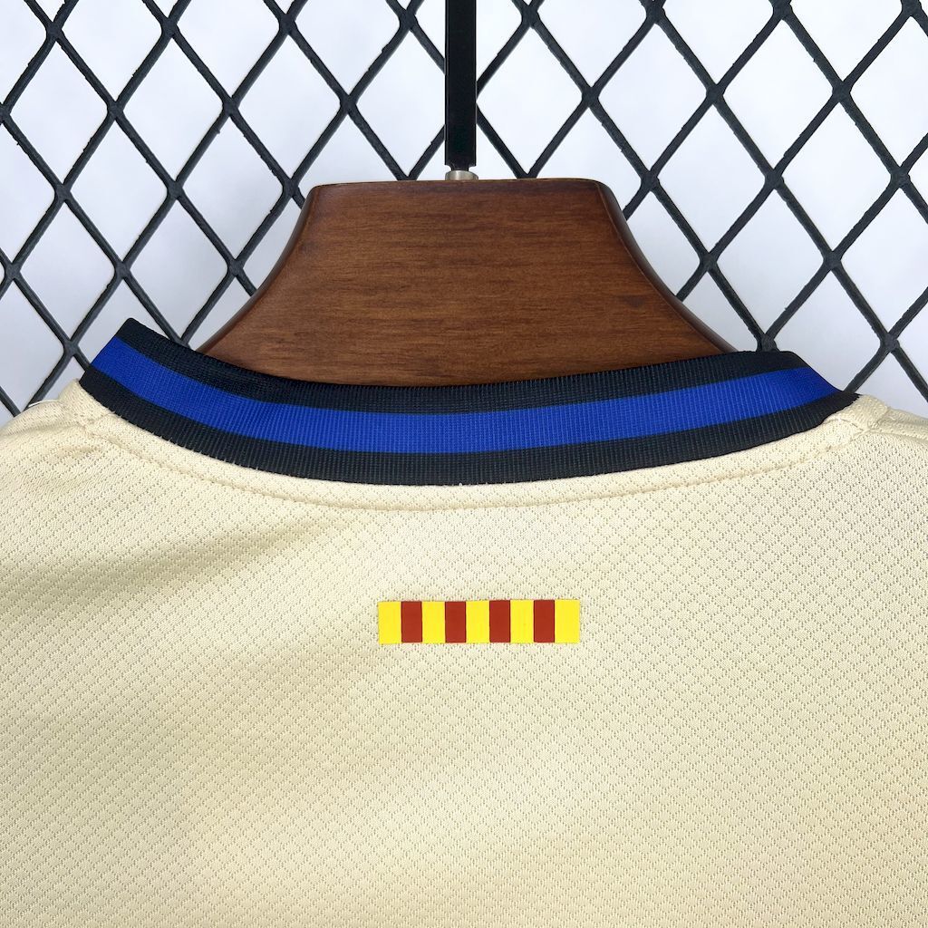 Cream kid jersey with blue ribbed collar and small multicolor chest badge