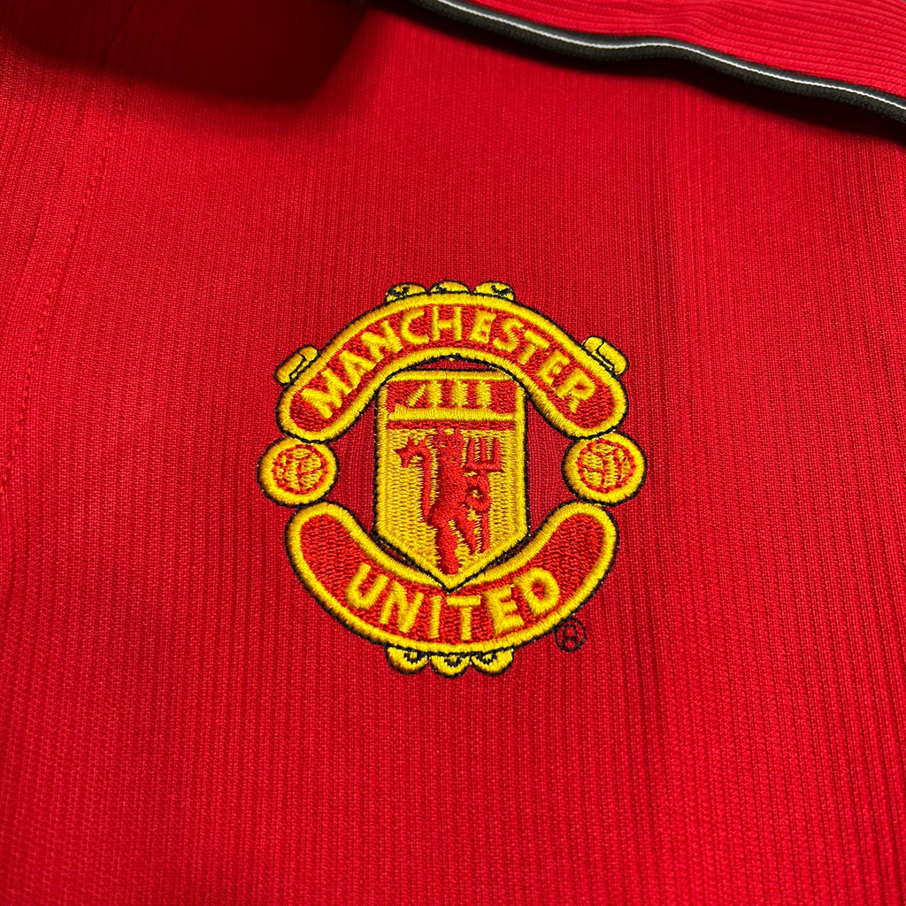 Yellow Manchester United crest on red jersey fabric