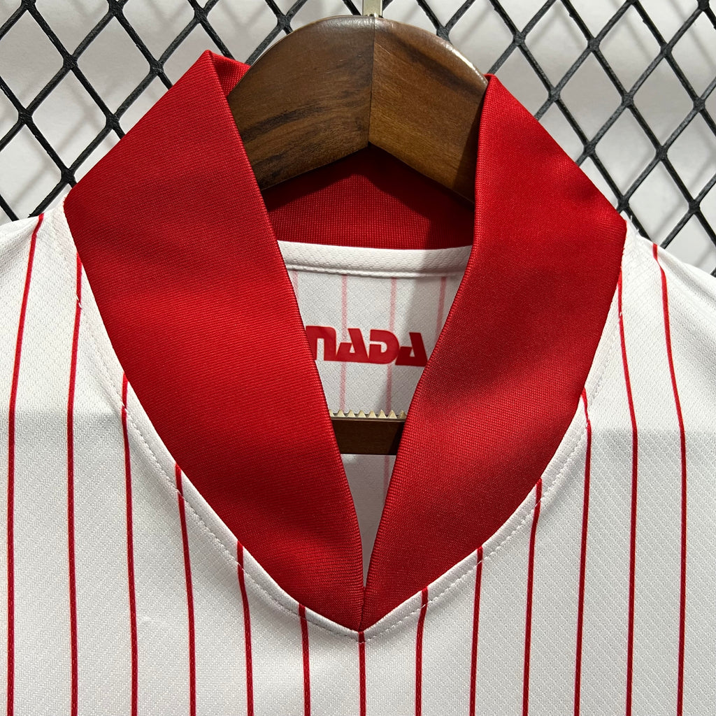 Red-trimmed V-neck collar on white jersey with Canada lettering at chest