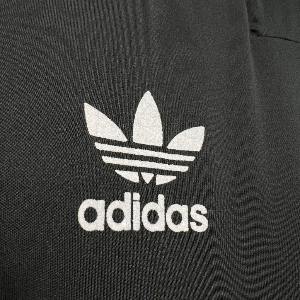 White adidas trefoil logo on black jersey chest