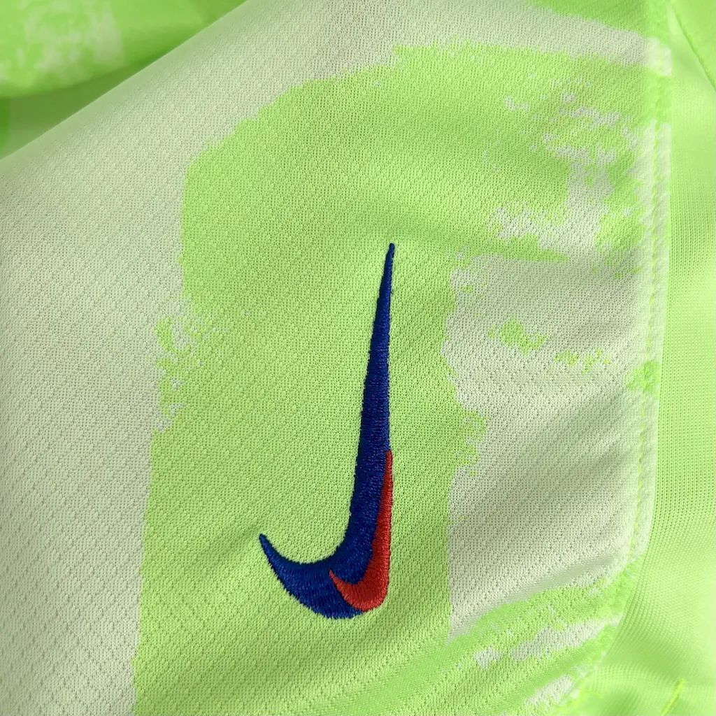 Neon lime fabric shorts with blue and red Nike swoosh logo close-up.