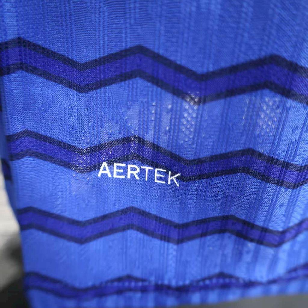 Blue home football jersey with dark zigzag stripes and AERTEK sponsor print.