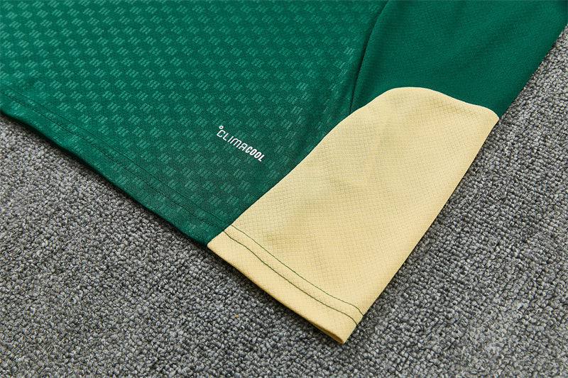 Green jersey cuff close-up with cream panel and small performance logo