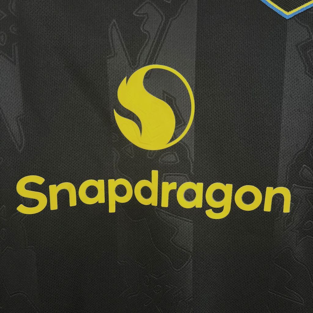 Women's third jersey sponsor logo, yellow 'Snapdragon' text on dark fabric.