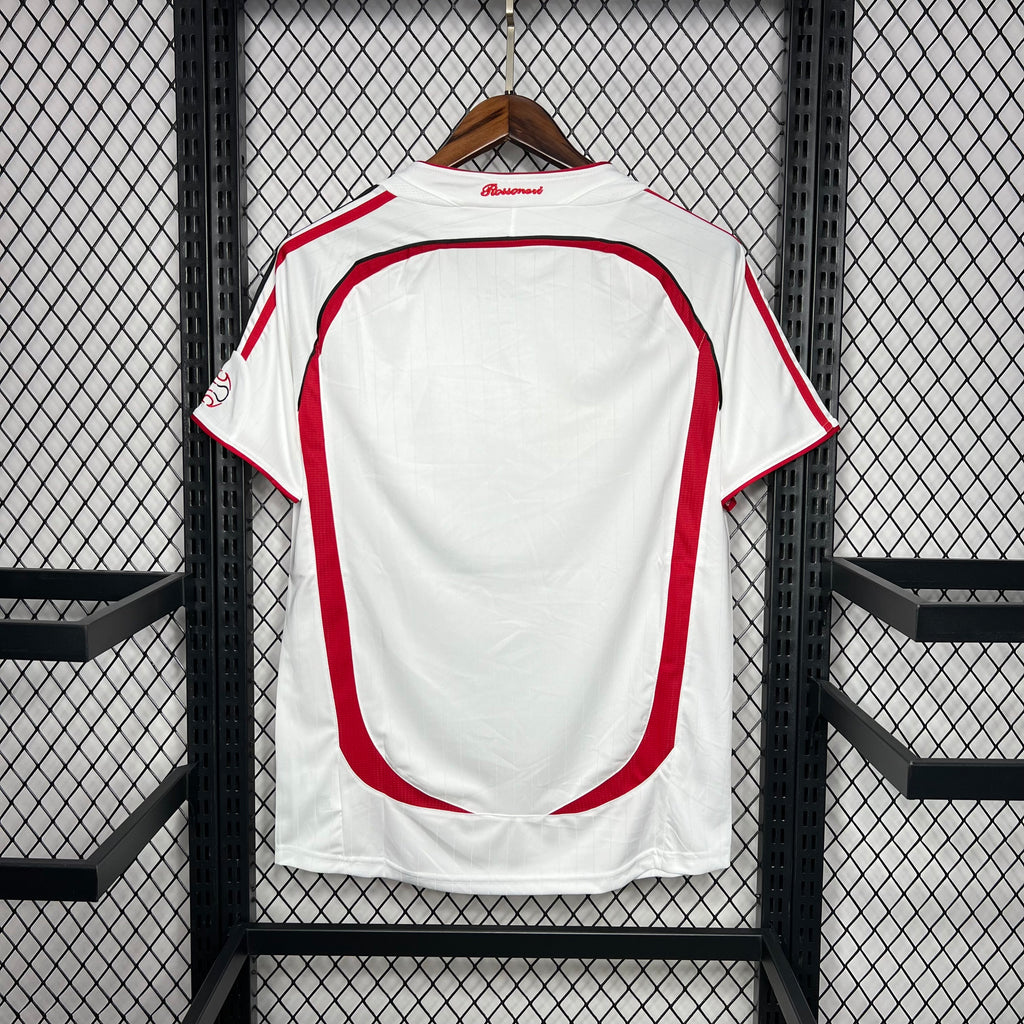 Back of white away soccer jersey with red side stripes and central panel