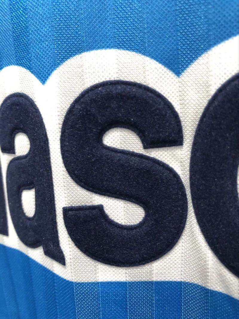 Panasonic sponsor print close-up on blue retro soccer jersey with white outline