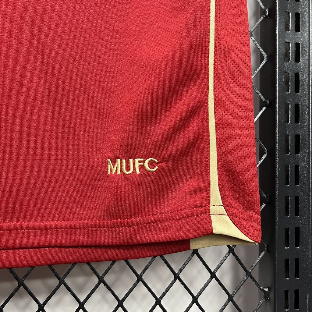 Red jersey fabric close-up with yellow MUFC marking near hem