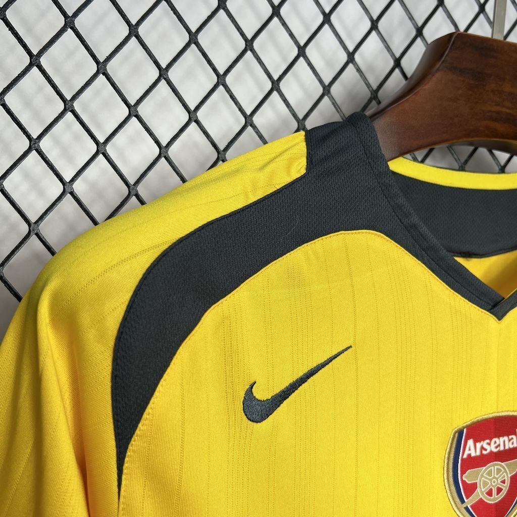 Yellow jersey shoulder with dark curved trim and Nike swoosh, crest edge visible