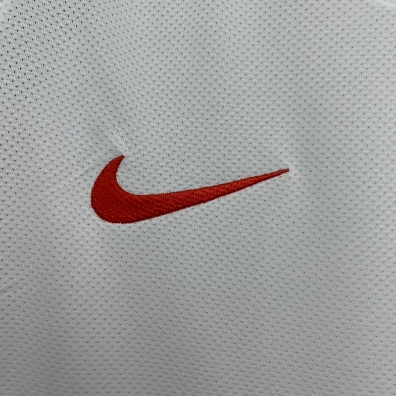 Red Nike swoosh logo on white textured away jersey