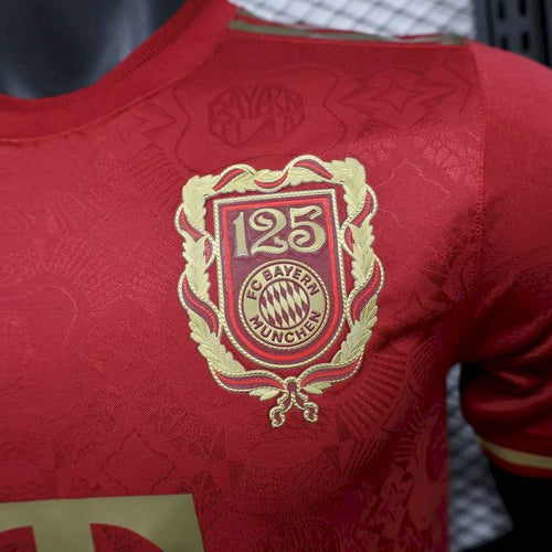 Red jersey chest closeup with gold FC Bayern 125th anniversary crest