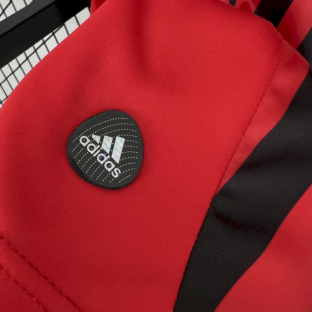 Red jersey sleeve with circular Adidas patch and black trim