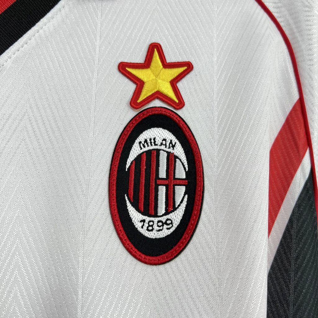 Chest close-up of AC Milan crest with star above on white jersey with red trim