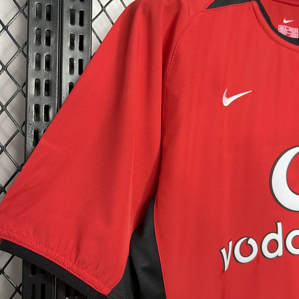 Red football shirt sleeve with Nike swoosh and Vodafone sponsor text
