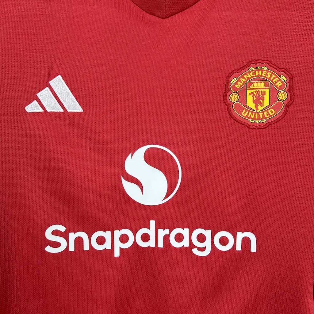 Kids red home shirt chest close-up with adidas logo, Snapdragons sponsor, and club crest