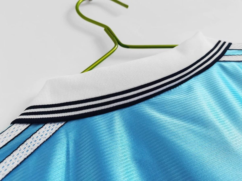 White-and-black striped collar detail on sky blue soccer jersey with knit trim