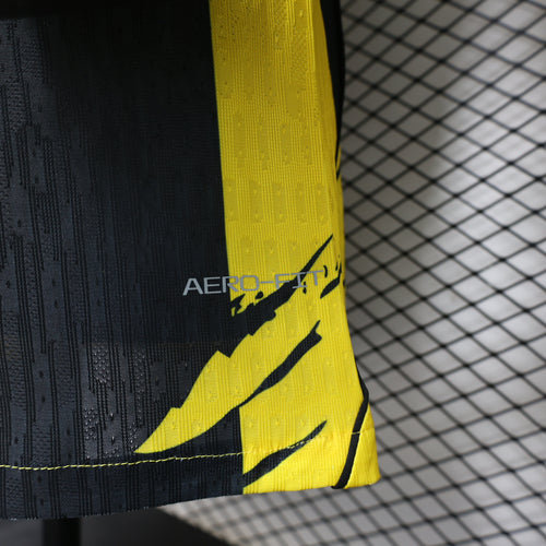 Black-and-yellow soccer jersey sleeve hem with Nike swoosh graphic, short sleeve.