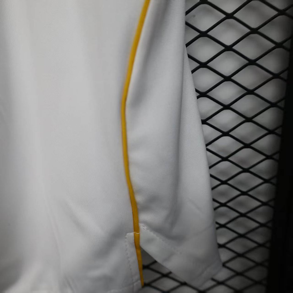 White shorts panel with yellow contrast piping along the outer seam.