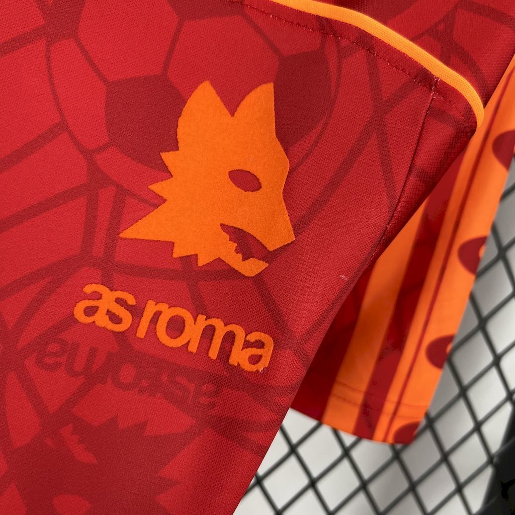 Red jersey sleeve shows orange star/leaf emblem and aroma text print.