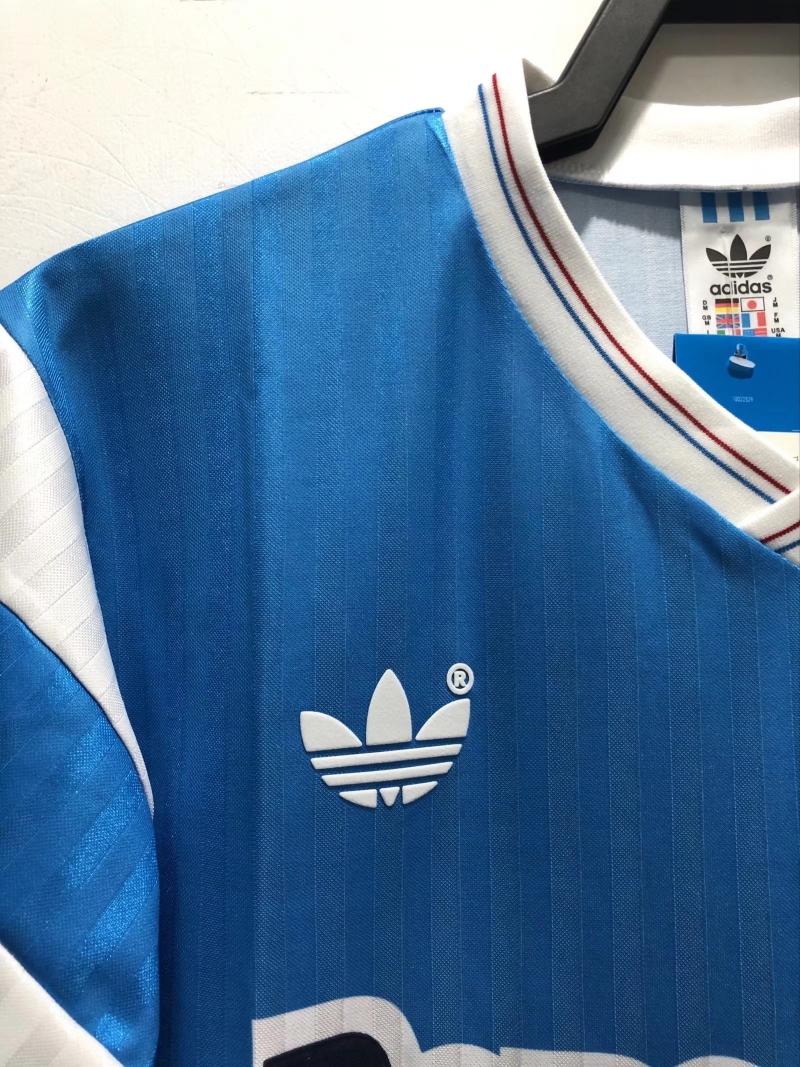 Blue retro soccer jersey shoulder view with adidas trefoil logo and striped collar