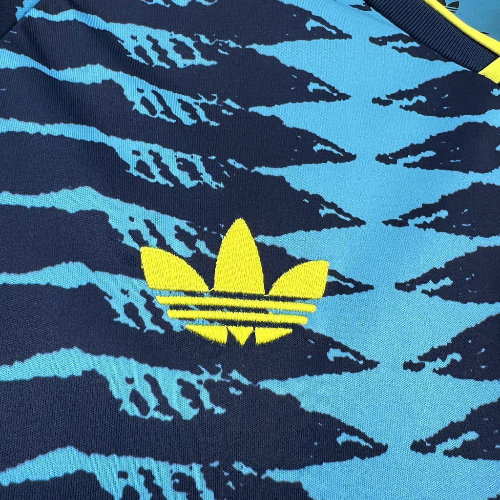 Jersey chest close-up with yellow flower crest logo on blue patterned background
