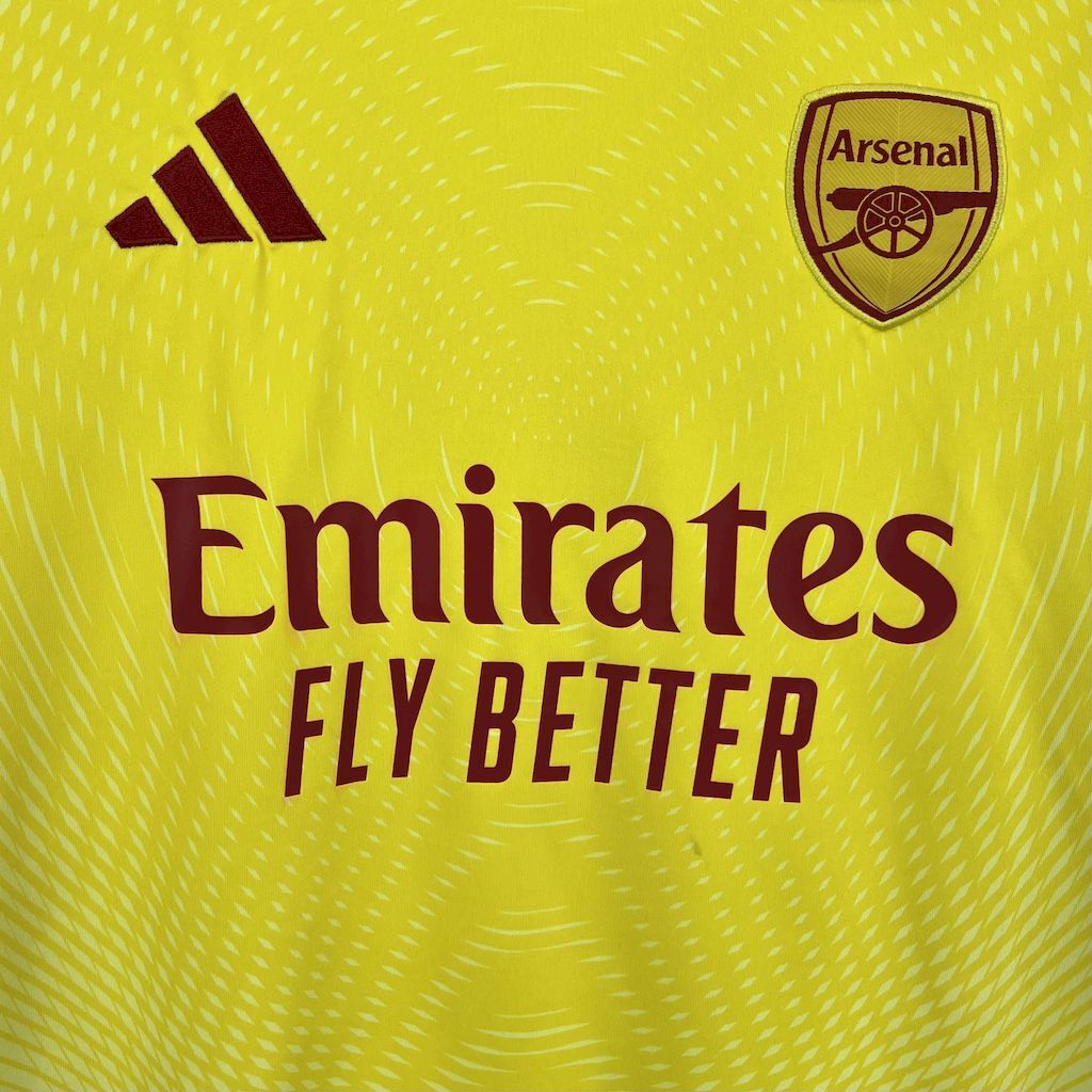 Neon yellow goalkeeper jersey with Adidas logo and 'Emirates Fly Better' text