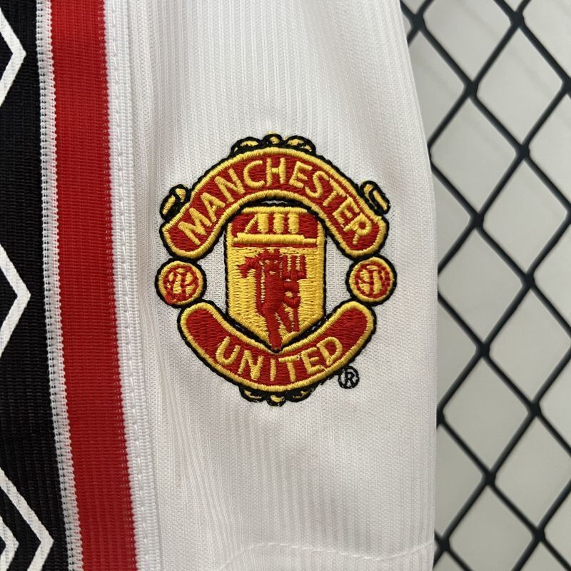 White kids soccer shorts with Manchester United crest and red patterned stripe