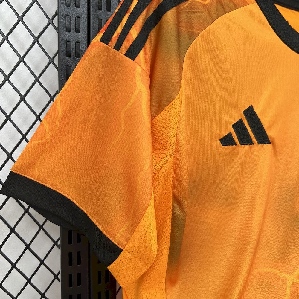 Orange soccer jersey side with black shoulder stripes and textured fabric