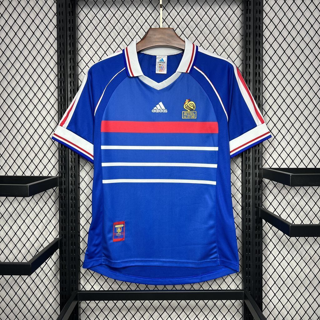 Blue retro France football jersey with white V-neck, red stripe accents, short sleeves.
