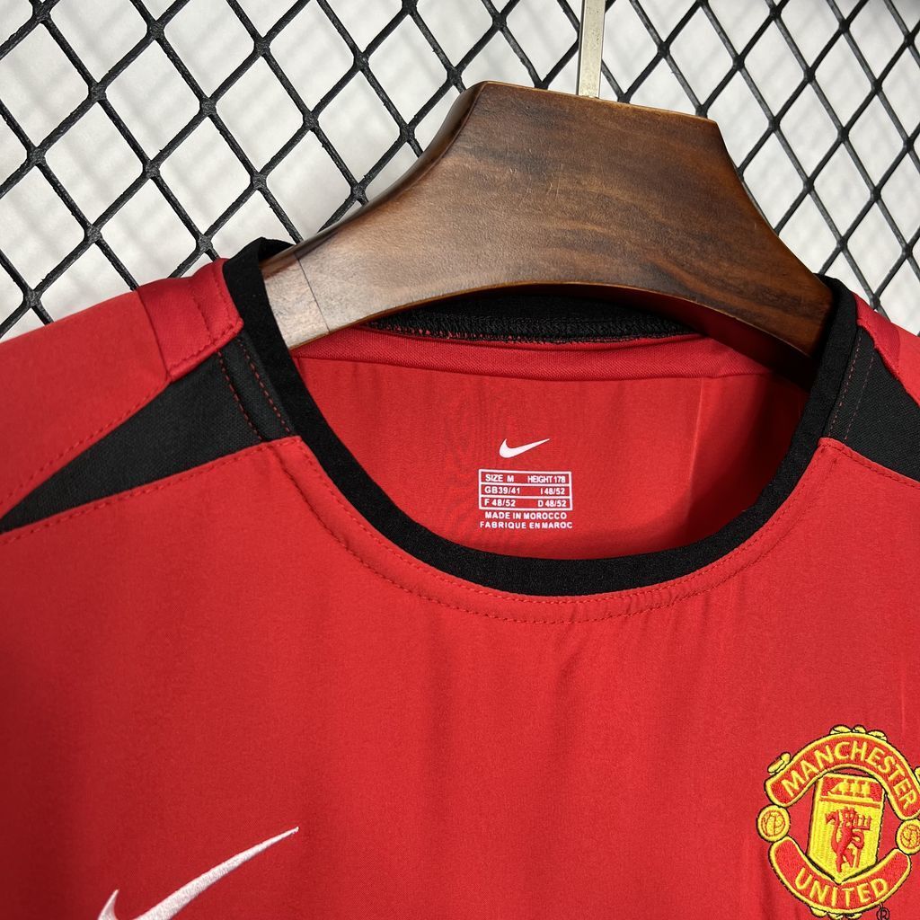 Red football shirt neckline with Nike swoosh and Manchester United crest on chest