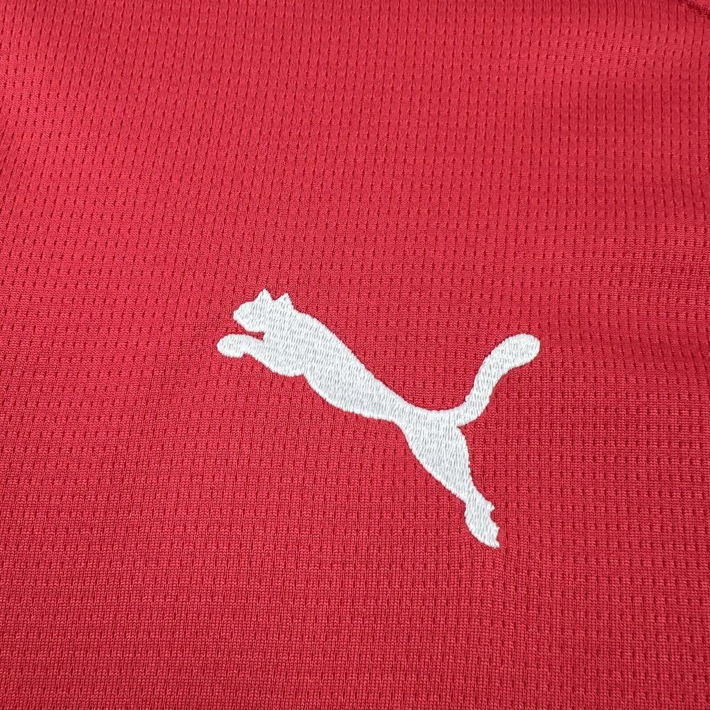 White Puma logo on textured red soccer jersey fabric