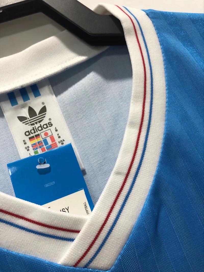 V-neck collar close-up with adidas label and red-blue-white stripe trim