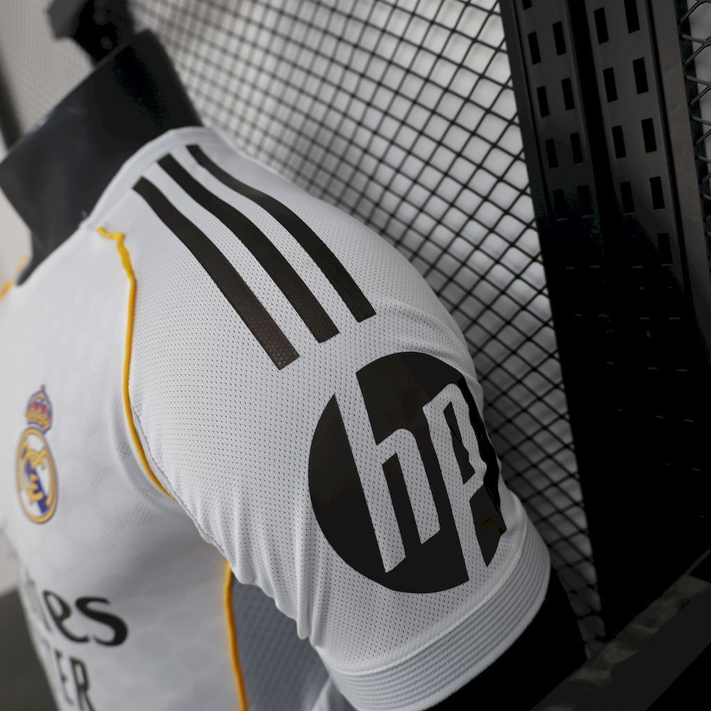 White football jersey sleeve close-up with black adidas stripes and yellow edge piping