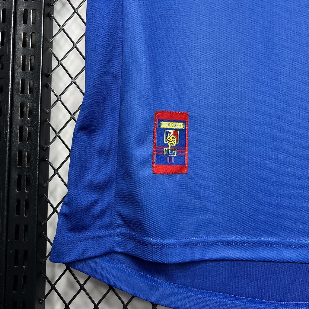 Blue France football jersey with red FFF crest patch on hem area.