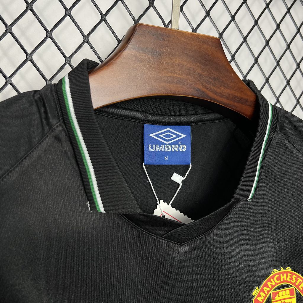 Black soccer jersey collar with Umbro label and green-white trim